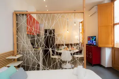 a room with a wall with a partition with a table at Apartment Collado in Valencia