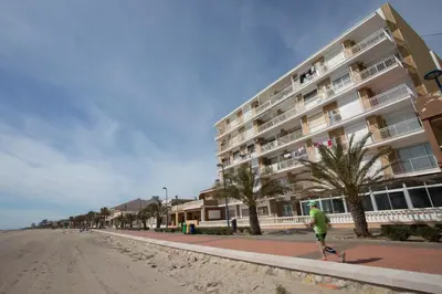 a man riding a skateboard down a street next to a building at SingularStays El Faro in Puzol