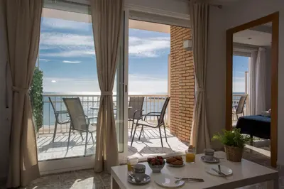 a room with a view of a balcony with a table and chairs at SingularStays El Faro in Puzol