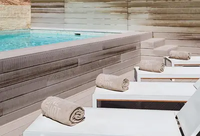 a pool with white lounge chairs and a swimming pool at One Shot Mercat in Valencia