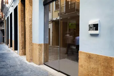 a one stick sign on the side of a building at One Shot Mercat in Valencia