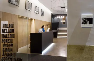 a woman sitting at a desk in a lobby at One Shot Mercat in Valencia