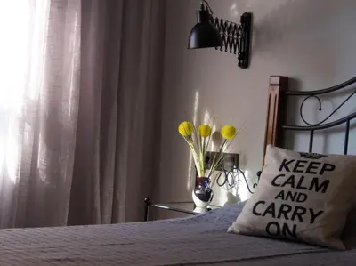 a bed with a pillow that says keep calm and carry on at Valencian Apartment in Valencia