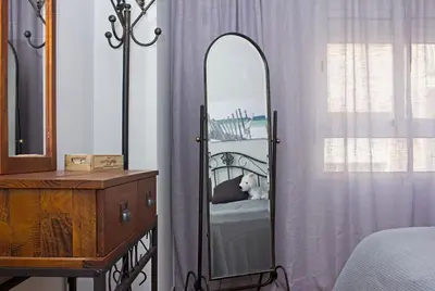 a mirror sitting next to a dresser in a bedroom at Valencian Apartment in Valencia