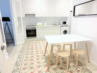 a kitchen with a white table and two stools at Total Valencia Vintage in Valencia