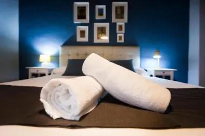 a bed with two white towels on top of it at Total Valencia Vintage in Valencia
