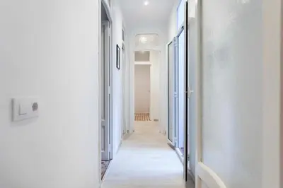 a hallway with white walls and a long hallway with blue doors at Total Valencia Vintage in Valencia