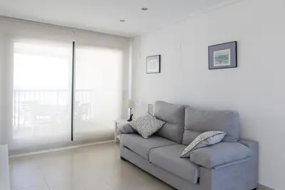 a living room with a couch and a window at ApartUP Patacona Horizon in Valencia
