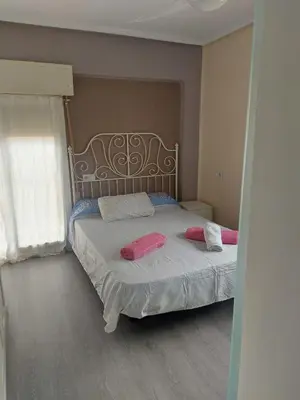 a bedroom with a bed with pink pillows on it at Malvarosa Beach Family in Valencia
