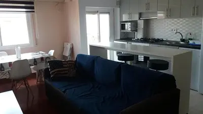 a living room with a couch and a kitchen at Malvarosa Beach Family in Valencia