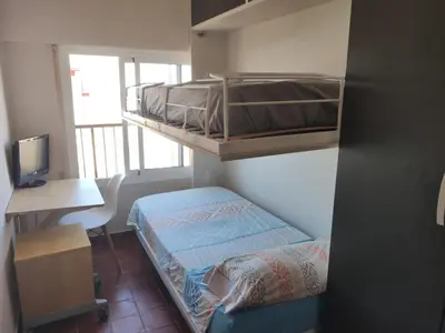 a small room with a bunk bed and a desk at Malvarosa Beach Family in Valencia