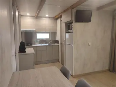 a bedroom with a white bed and wooden walls at Camping-Bungalows Altomira in Navajas
