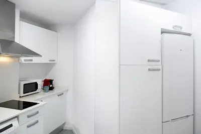 a white kitchen with white cabinets and a microwave at San Jaime Silence in Valencia