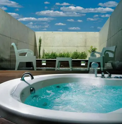 a bath tub with a water fountain on a patio at Shhh in Onda