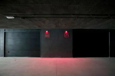 a garage with two garage doors and red lights at Shhh in Onda