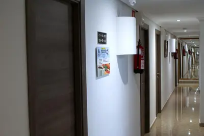a hallway in a building with a door and a sign on the wall at Hotel Carabela 2 in Cullera