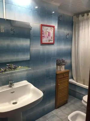 a blue tiled bathroom with a sink and a toilet at Florazar de Ensueño in Cullera