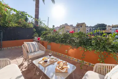 a patio with a table and chairs with food on it at Travel Habitat Casa con embarcadero. in Port Saplaya