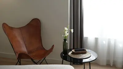 a room with a chair and a table with a vase at MD Design Hotel - Portal del Real in Valencia