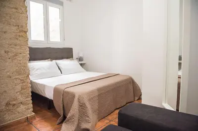 a bed in a white room with a window at Ambrosio Flats Valencia - El Carmen in Valencia
