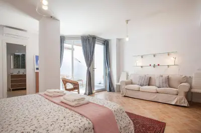 a white bedroom with a bed and a couch at Habana Apartment in Valencia