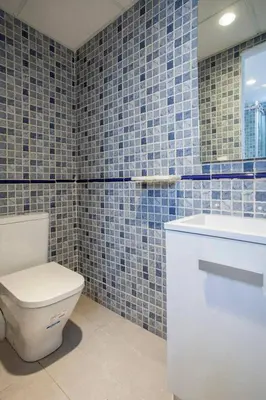 a blue tiled bathroom with a toilet and a sink at Habana Apartment in Valencia