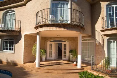 a brick house with a balcony and a door at MD Villa Cullera Cap Blanc in Faro de Cullera