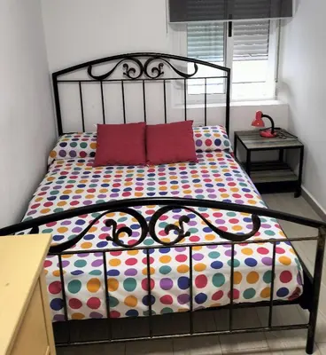 a bed with two red pillows in a bedroom at New Trendy apartment in Valencia