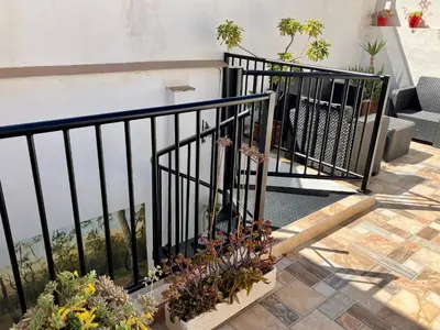 a balcony with a black railing and some plants at Casa Cabanyal in Valencia