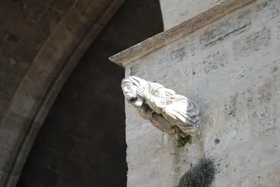 a stone gargoyle on the side of a building at Travel Habitat Jardines Rio Turia. in Valencia