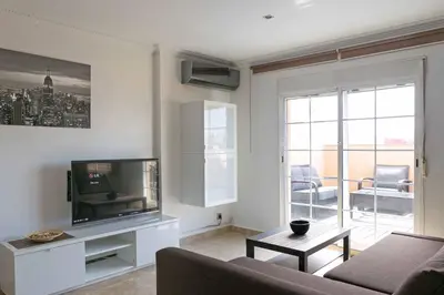 a living room with a flat screen tv and a couch at Attic Valencia Beach in Valencia