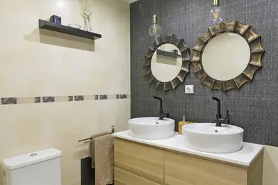 a bathroom with two sinks and two mirrors at Attic Valencia Beach in Valencia