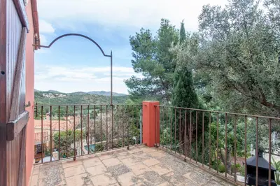 a balcony with an iron fence and a view of the mountains at Ca Carmela casa con Encanto con Piscina 