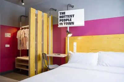 a bedroom with a bed and a sign that reads the hottest people in town at room00 Valencia Hostel in Valencia