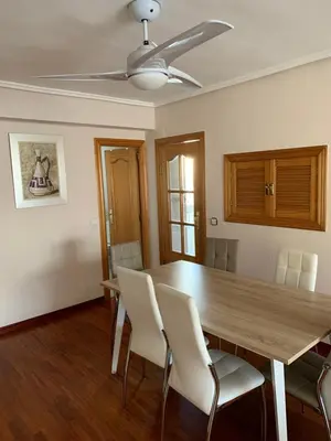 a dining room table with white chairs and a ceiling fan at Apartamento Playa el Cabanyal in Valencia