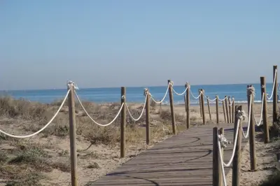 a wooden path to the beach with rope barriers at Hotel Playa Canet in Canet de Berenguer