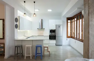 a kitchen with white cabinets and blue stools at TTdSSa VLC Purísima Street in Valencia
