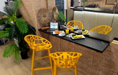 a table with a laptop on top of it with chairs at Hotel Valldigna in Tavernes de Valldigna