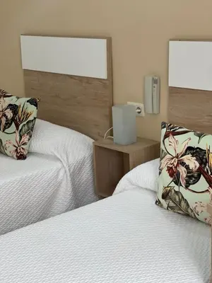 a bedroom with two beds and a window at Hotel Valldigna in Tavernes de Valldigna