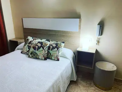 a small bedroom with a bed with two pillows at Hotel Valldigna in Tavernes de Valldigna