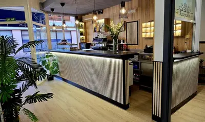 a restaurant with a bar in the middle of a room at Hotel Valldigna in Tavernes de Valldigna
