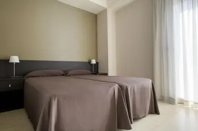 a bedroom with a large bed with a gray blanket at Residencia Universitaria Resa Damia Bonet in Valencia