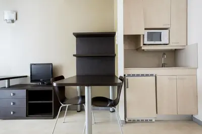 a small kitchen with a desk and a table with chairs at Residencia Universitaria Resa Damia Bonet in Valencia