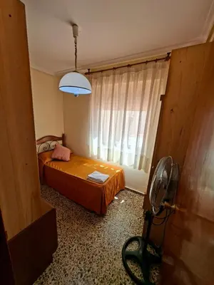 a bedroom with a bed and a window with a fan at APARTAMENTO BEATRIZ 2 in Burriana