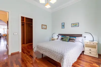 a white bedroom with a bed and a wooden floor at Ruzafa Luis Santangel in Valencia