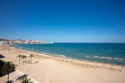 a group of people on a beach with the ocean at Apartments Cullera Beach in Cullera