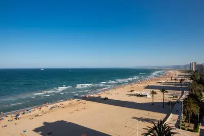 a beach with a lot of people and the ocean at Apartments Cullera Beach in Cullera