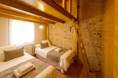 a room with two beds and a brick wall at MD Sueca in Valencia