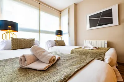 a bedroom with two beds and a tv on the wall at MD Abastos in Valencia