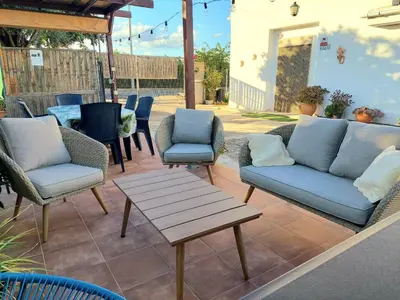 a patio with chairs and a table and a couch at Ca Emma in Mahuella